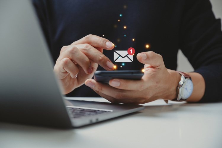 通知アラート付きのメールを使用するビジネスマンの手